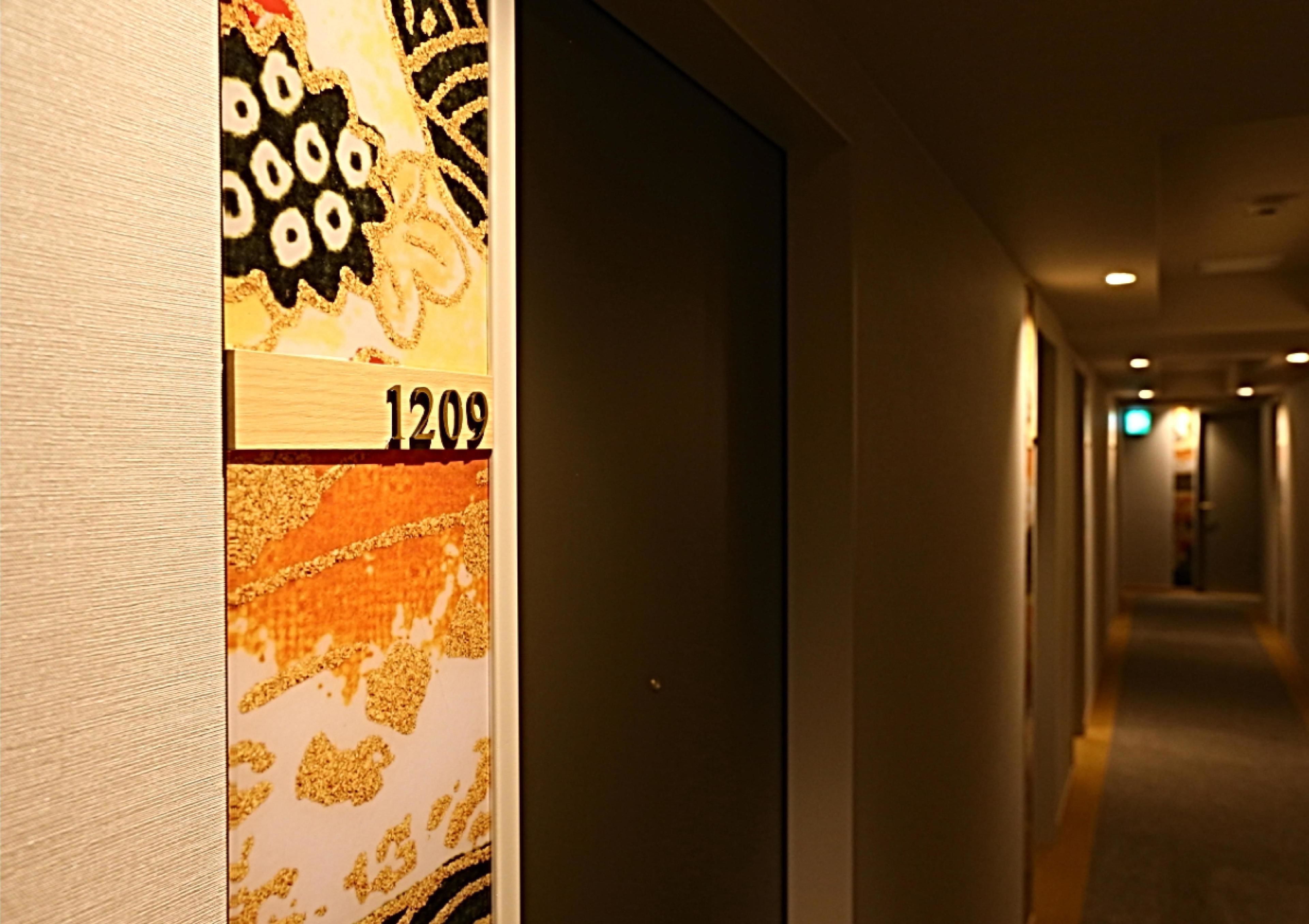 A hallway with a wall featuring a number '1209' and a decorative pattern.
