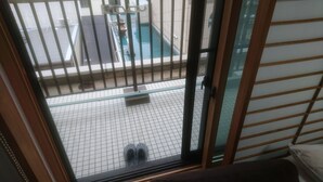 Una habitación con puerta corrediza de vidrio que da a un balcón con piscina.