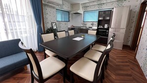 Una cocina moderna con zona de comedor, que incluye una mesa grande, sillas y un sofá azul.