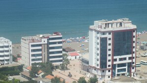 A hotel with multiple floors, a beach view, and a sign for 'HOTEL SYPHAX'. - Hotel Syphax (Bejaia)