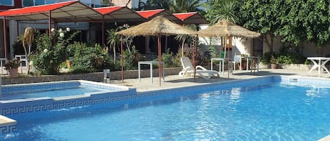Piscine couverte, piscine extérieure, parasols de plage, chaises longues