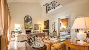 Un salón amplio con chimenea, asientos cómodos y un comedor con una bandeja de bebidas.