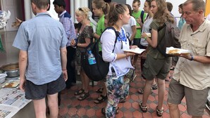 Un groupe de personnes faisant la queue, peut-être devant un comptoir de restauration.