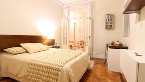 Ein Schlafzimmer mit Bett, Nachttisch, Lampe und einem kleinen Schreibtisch mit Spiegel.