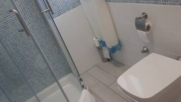 Ein Badezimmer mit Dusche, Toilette und Waschbecken.