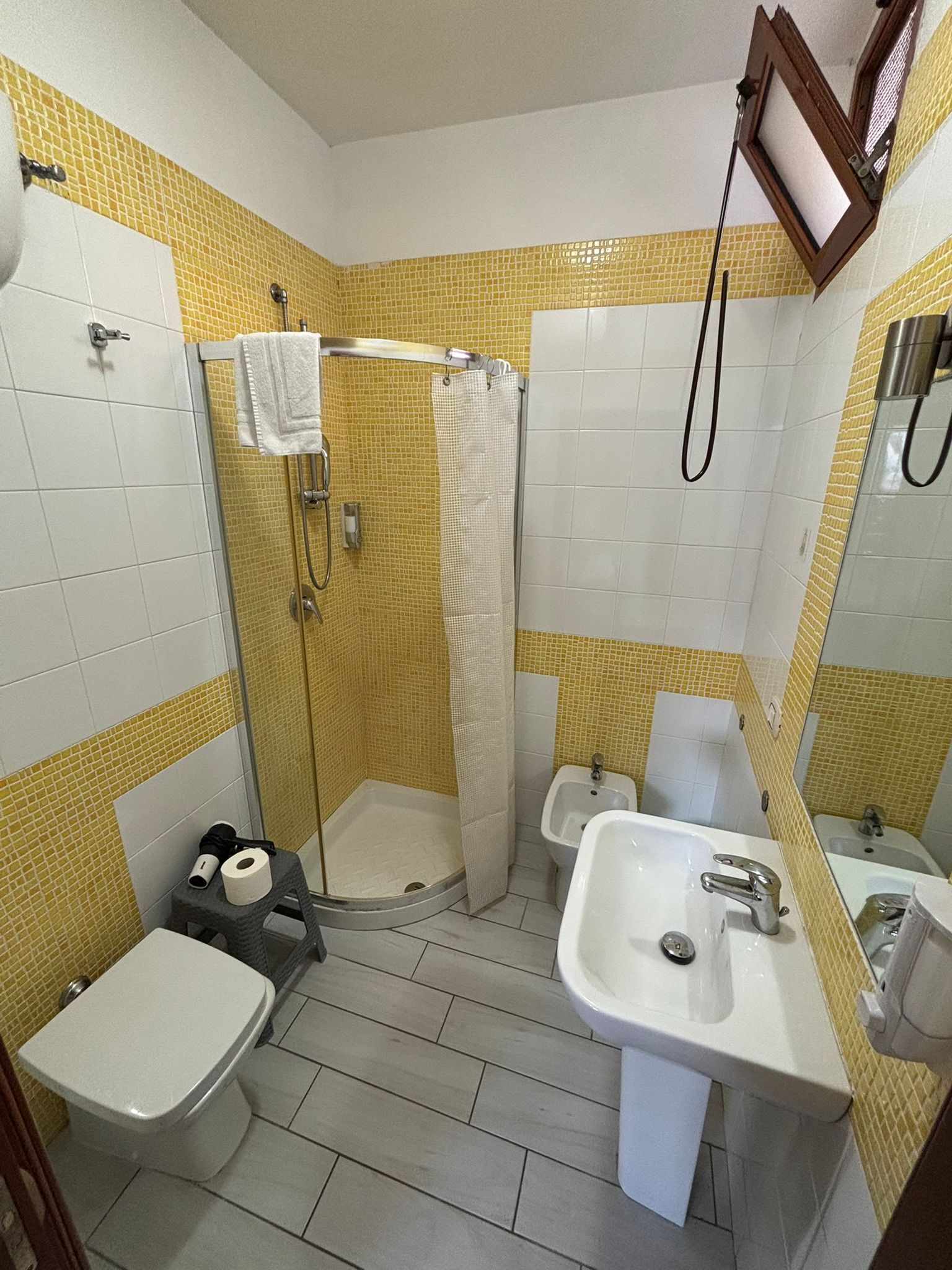 Un bagno con doccia, WC, bidet e lavandino.