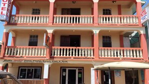 Ett hotell med en skylt som visar vägen till en närliggande park, balkonger och en restaurang som heter Bella Italia.