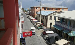 A street view with parked vehicles, a Coca-Cola sign, and buildings with commercial establishments. - Hotel Central Park (San Pedro)