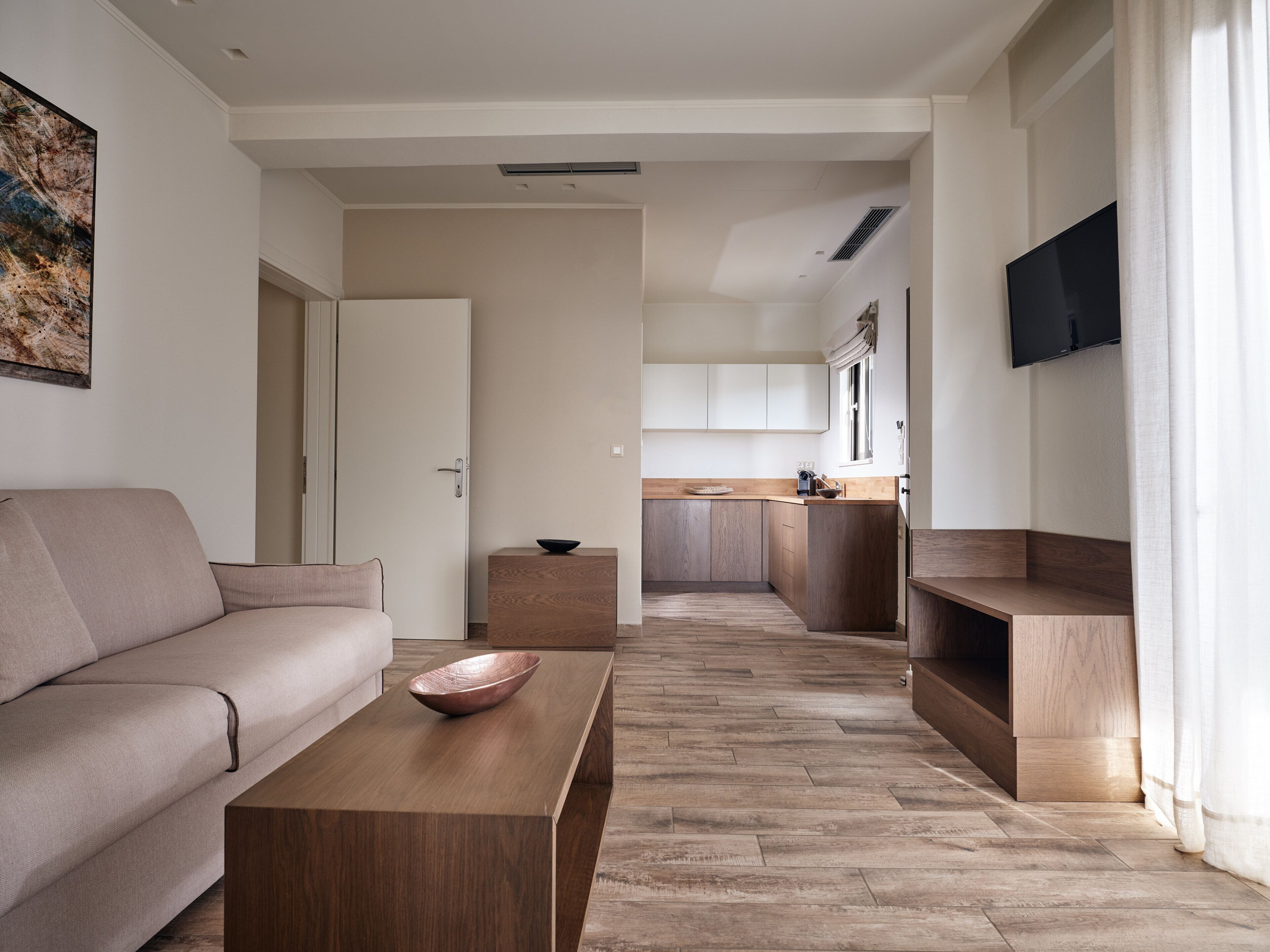 Ein modernes Wohnzimmer mit einer Couch, einem Couchtisch und einer Küche im Hintergrund.