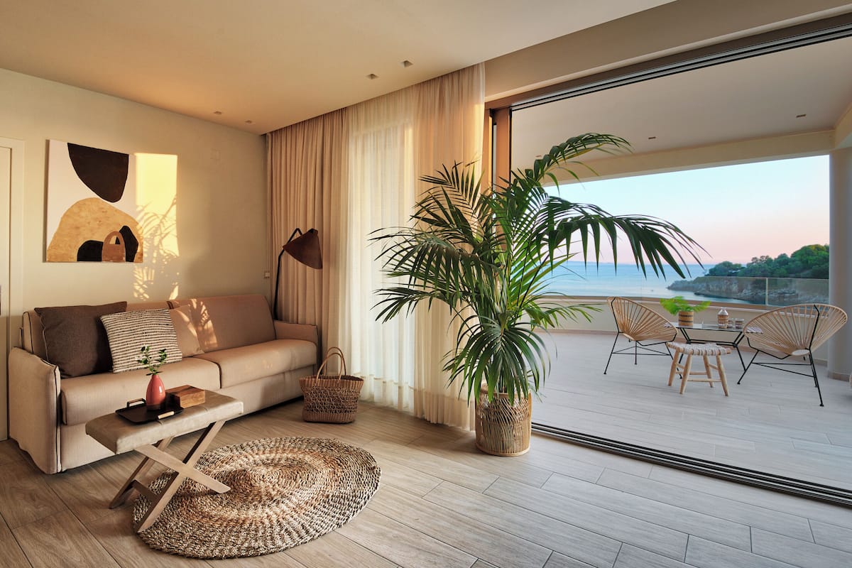 Una sala de estar moderna con sofá, mesa de centro y un ventanal con vistas a un balcón.