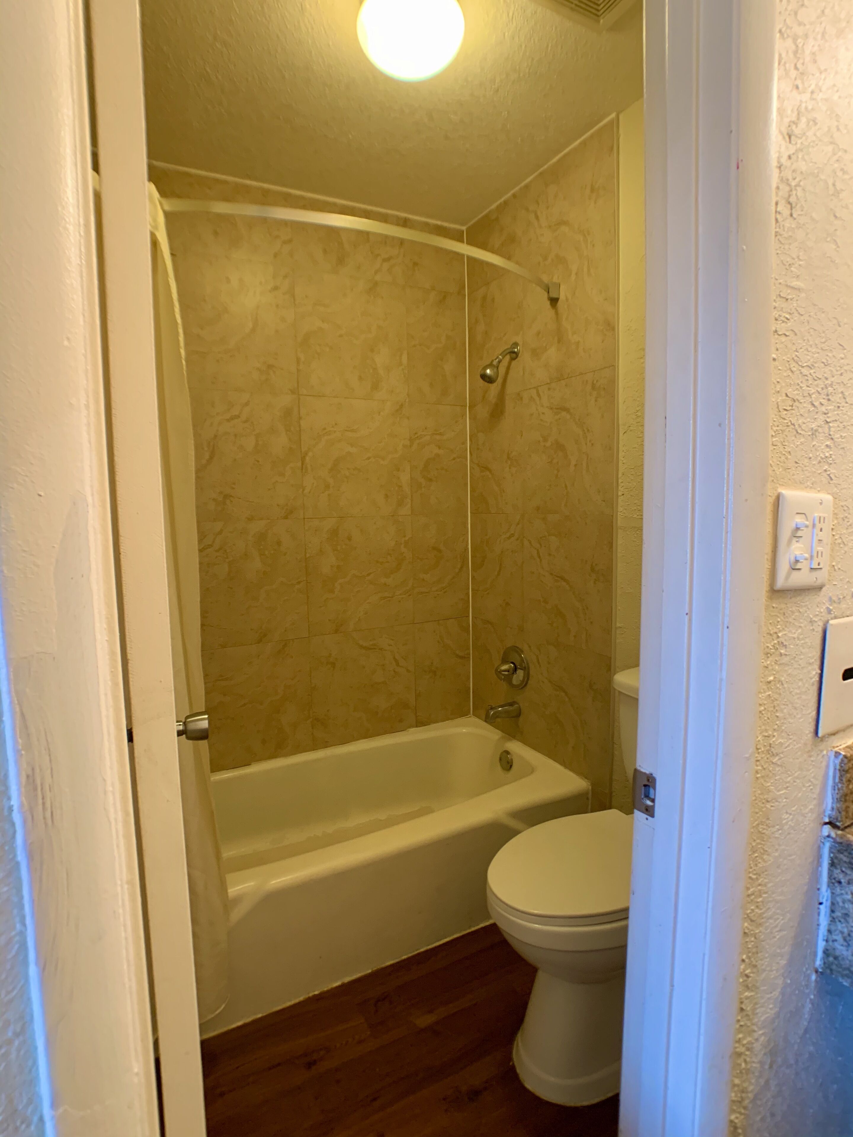 Un baño con bañera, inodoro y zona de ducha.
