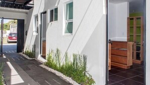 A modern house with a covered porch, a tiled patio, and a small garden area. - 2NDHOME Celaya (Celaya)