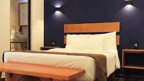 A bedroom with a wooden bed frame, a bedside table, a bench, and a nightstand. - 2NDHOME Celaya (Celaya)