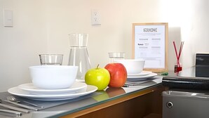 A kitchen counter with a white bowl, a glass pitcher, and two apples on a plate. - 2NDHOME Celaya (Celaya)