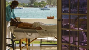 A massage therapy session in a room with a view of the sea and boats. - Bay Pointe Yacht Club 2BD Apartment OLR (Montego Bay)