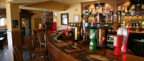 A bar area with multiple beer taps, including brands like Guinness and Heineken, and a variety of liquor bottles.