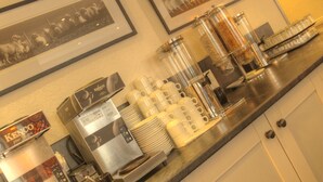 A coffee station with a coffee machine, cups, and containers on a counter. - Tongadale Hotel (Portree)