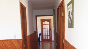 Un pasillo con paneles de madera y una puerta al final.
