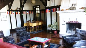 Una sala de estar acogedora con muebles de madera, chimenea y comedor con mesa y sillas.