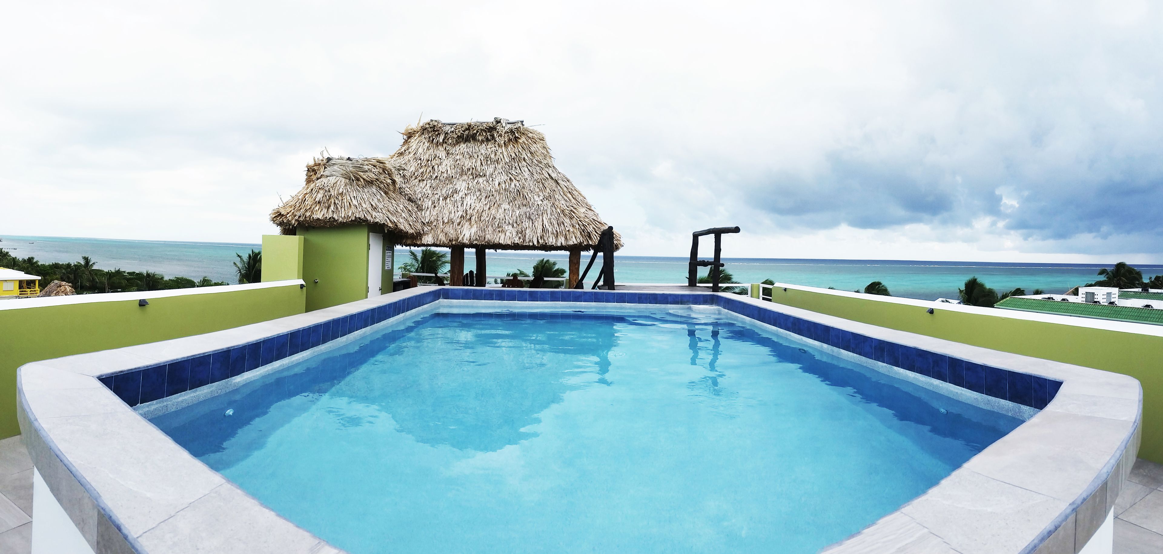 Una piscina al aire libre, sillones reclinables de piscina