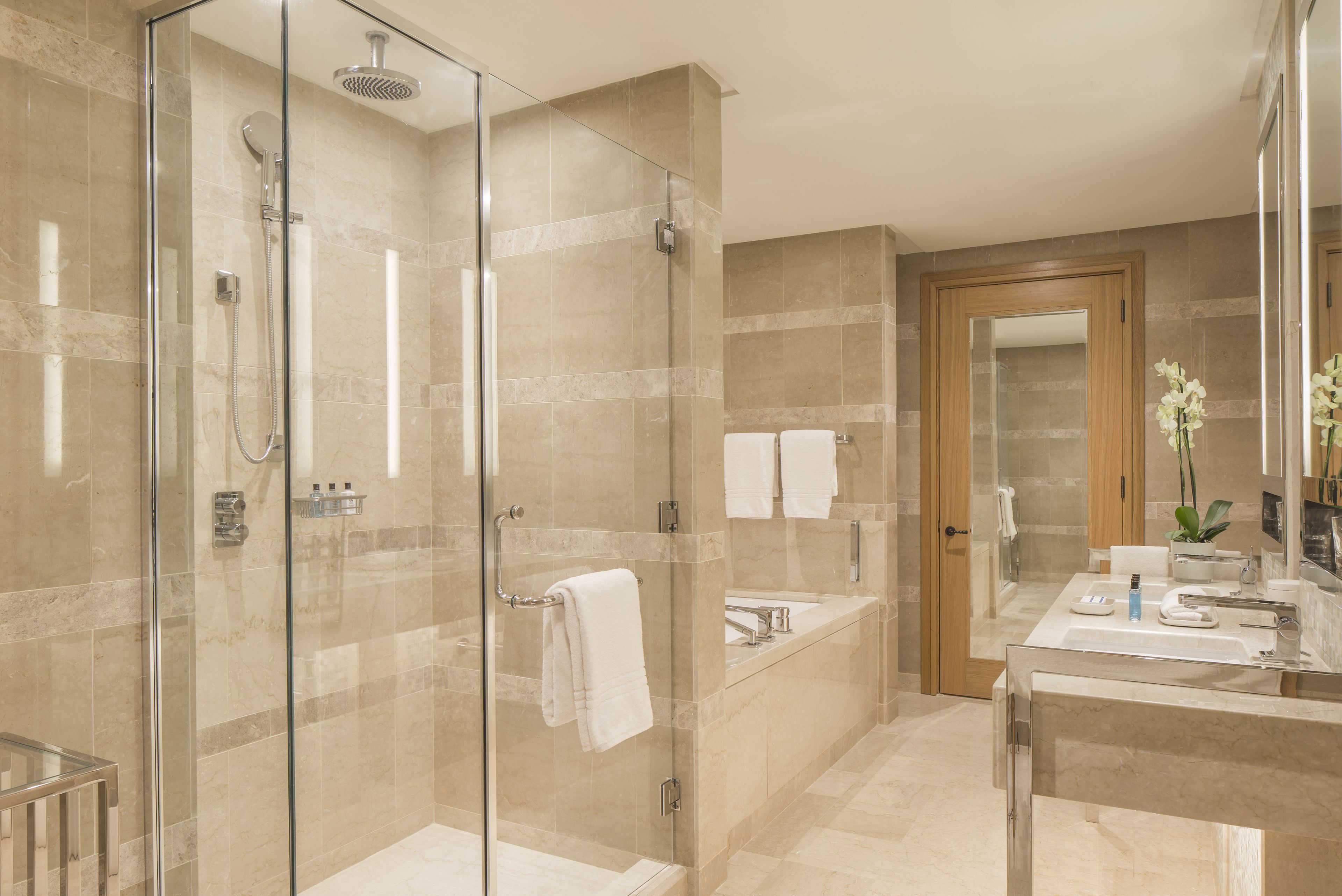 Ein modernes Badezimmer mit einer Duschkabine, einer Badewanne, einem Waschtisch und einem Spiegel.