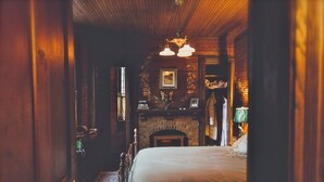 Una habitación acogedora con cama, chimenea y techo de madera.