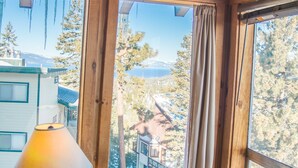 A wooden interior with large windows, a lamp, and a bottle on a wooden table. - Lake Views! Perfect Mountain Summer Get-a-way No traffic, 8,000 ft. elevation (Stateline)
