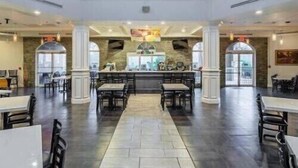 A spacious indoor area with a central bar, multiple seating arrangements, and a stone wall backdrop. - Elite end unit, sleeps 10, 5 min walk to pool, many extras. Close to Disney. (Davenport)