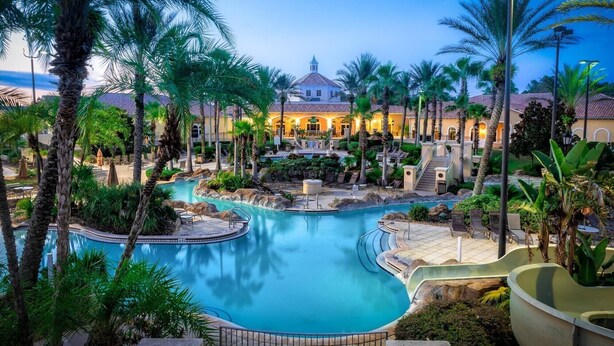 A resort with a central pool, palm trees, and a building with a dome roof. - Elite end unit, sleeps 10, 5 min walk to pool, many extras. Close to Disney. (Davenport)