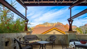 A covered patio with wicker furniture, a table, and a bowl. - Walk a Block to Uptown, to the main shops, tours, restaurants. (Sedona)