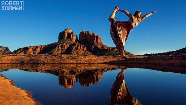 A person performing a yoga pose on a reflective surface with a desert landscape in the background. - Walk a Block to Uptown, to the main shops, tours, restaurants. (Sedona)