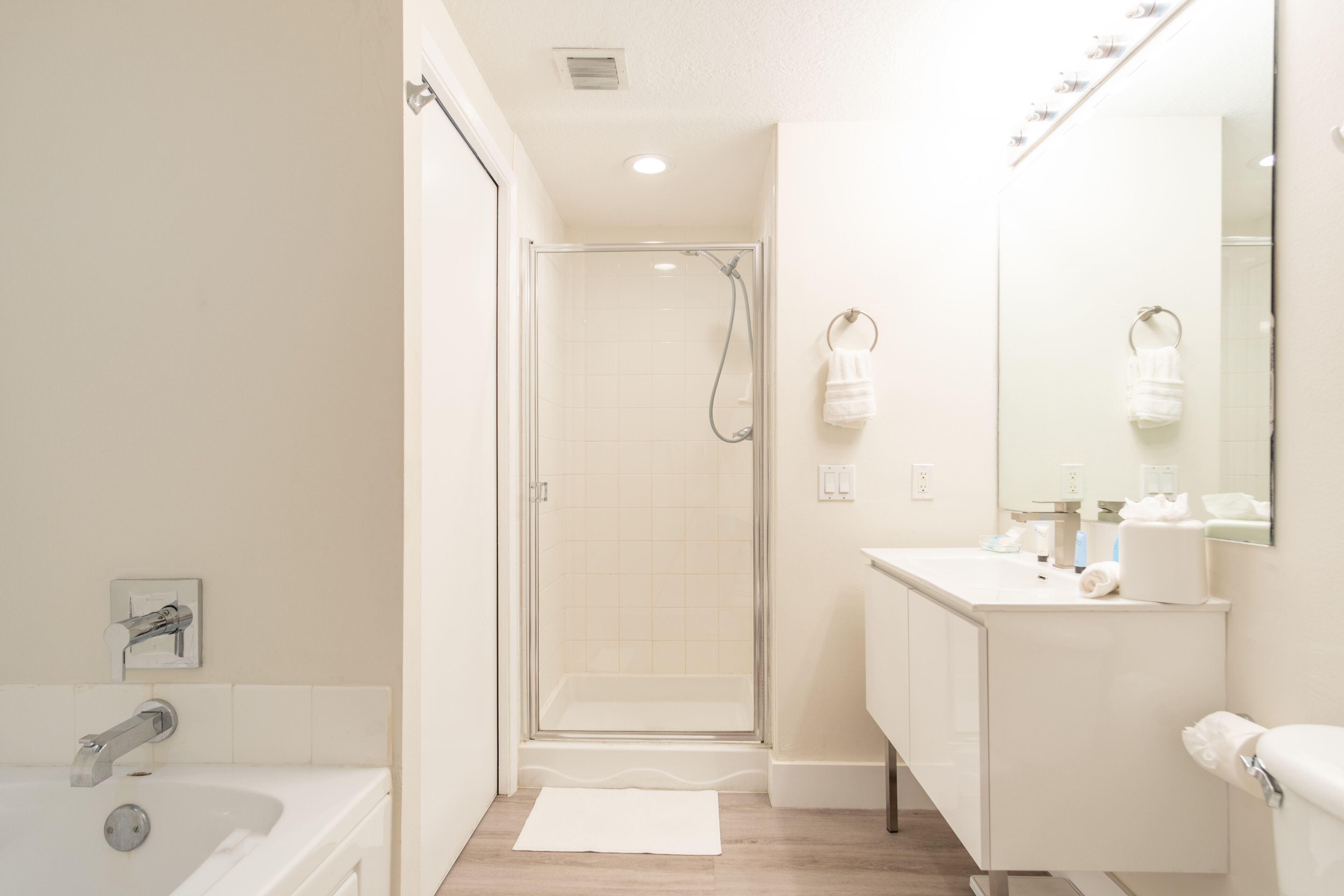 Une salle de bain moderne avec une douche à parois de verre, un lavabo blanc et un miroir.