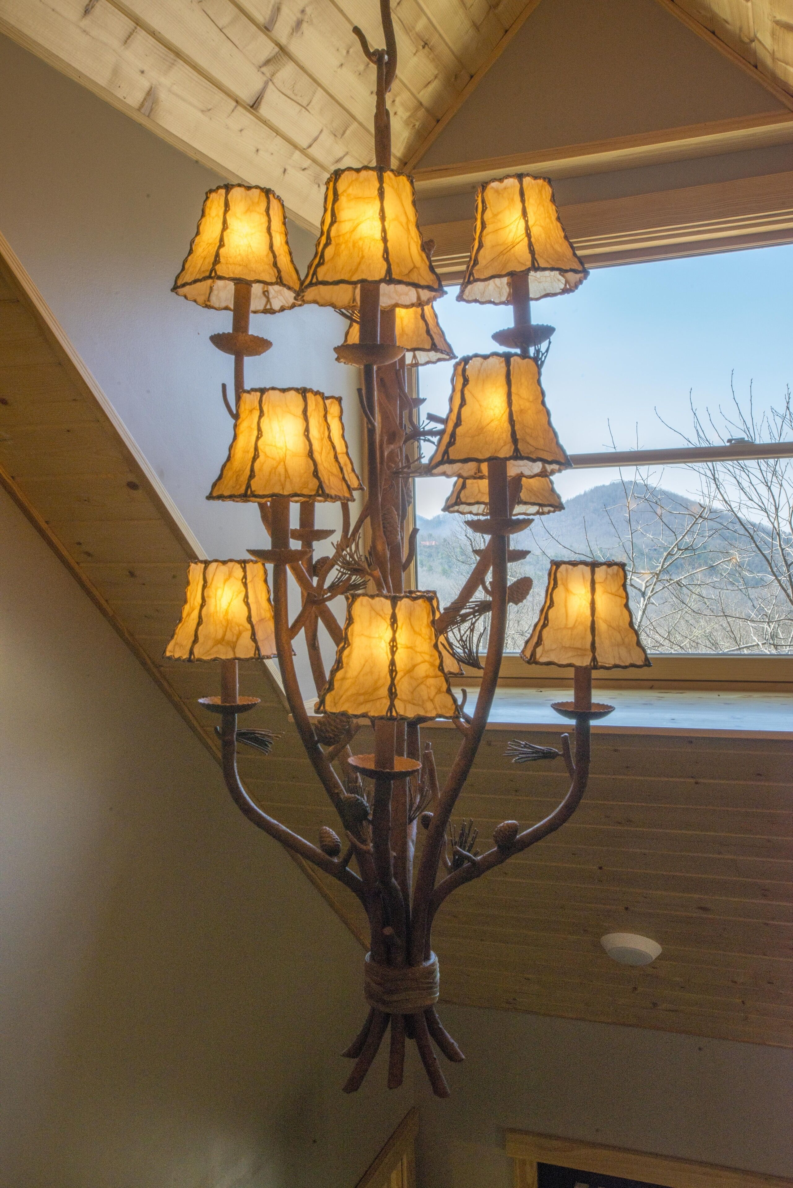 A chandelier with multiple lampshades hanging from a central rod.