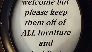 A framed sign with a message about pet policy.