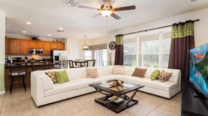 A modern living room with a sectional sofa, a coffee table, and a television.