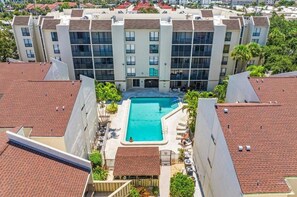 Ein mehrstöckiges Hotel mit einem zentralen Swimmingpool, umgeben von Balkonen.
