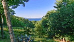 Uma área arborizada com uma mesa e cadeiras para refeições ao ar livre, com vista para uma paisagem deslumbrante.