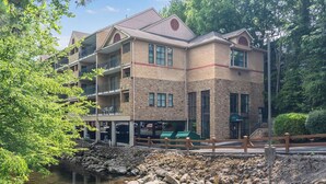 En bygning med flere etager, facade i sten, altaner og en parkeringsplads.