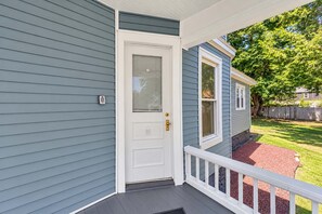 A house with a front porch, a white door, and a mailbox.