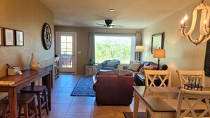 A spacious living area with a dining table, chairs, a sofa, and a chandelier. - Perfect condo in foothills of the Catalina Mountains with Spectacular Views (Tucson)