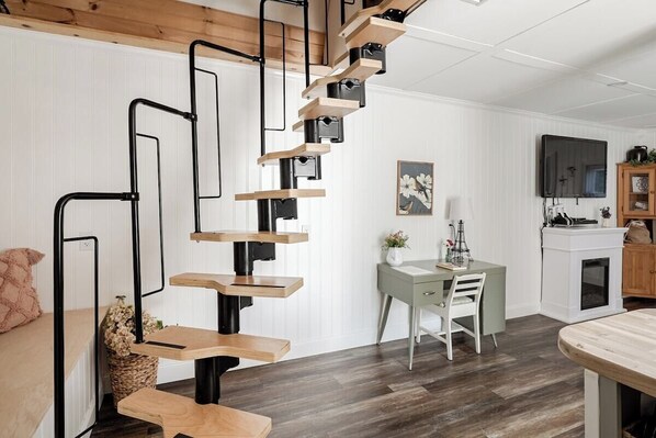 A modern interior with a spiral staircase, a dining area, and a television. - ⭐️Wildflower Country Cottage (Oxford)