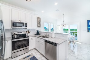 Enjoy cooking in this well-equipped kitchen with a large island, dishwasher, microwave, oven, and coffee maker.