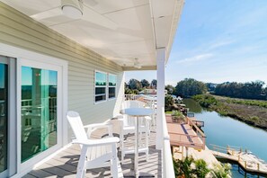 Relax on the deck with a view of the calm river and lush greenery.