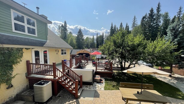 A patio area with outdoor seating, a wooden deck, and a stone pathway. - VACATION RENTAL- SLEEPS UP TO 10 -GOLDEN BC (Blaeberry)