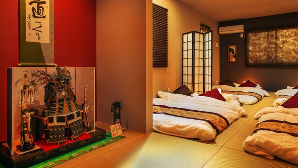 A traditional Japanese room with tatami flooring, shoji screens, and a display of samurai armor. - Samurai House (Nagoya)