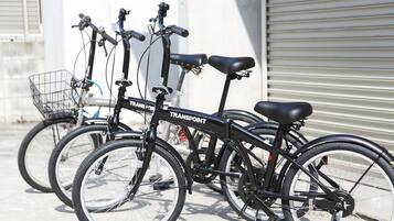 A row of bicycles parked outside a building with a metal shutter door.