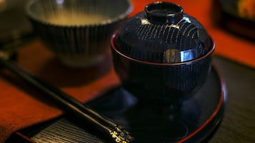 A close-up of a black teapot with a lid on a tray.