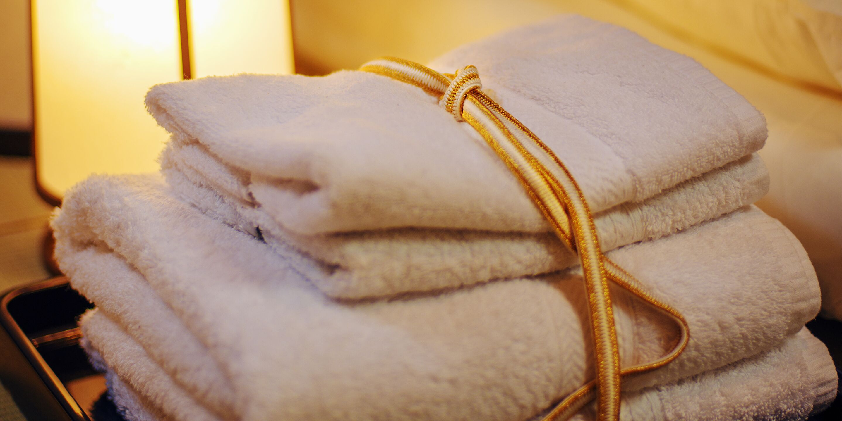 A stack of folded towels tied with a golden string.