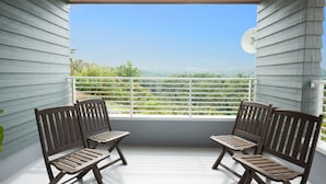 A balcony with two wooden chairs and a white railing, overlooking a scenic landscape. - The Pool Resort Villa ICHIGOICHIE (Onna)