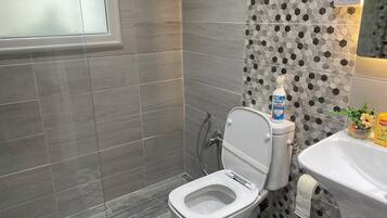 Un baño moderno con inodoro, lavamanos y ducha.
